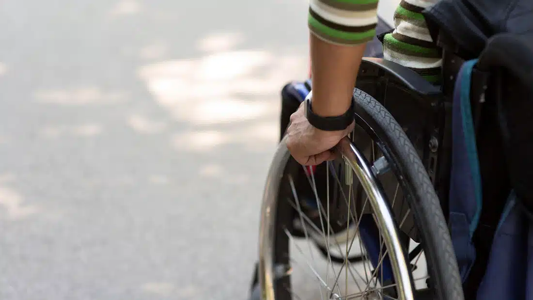 Hand pushing a wheelchair